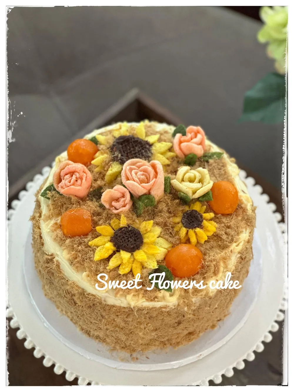 Salted egg sponge cake topped with buttercream sunflowers, peach and cream roses and salted egg yolks
